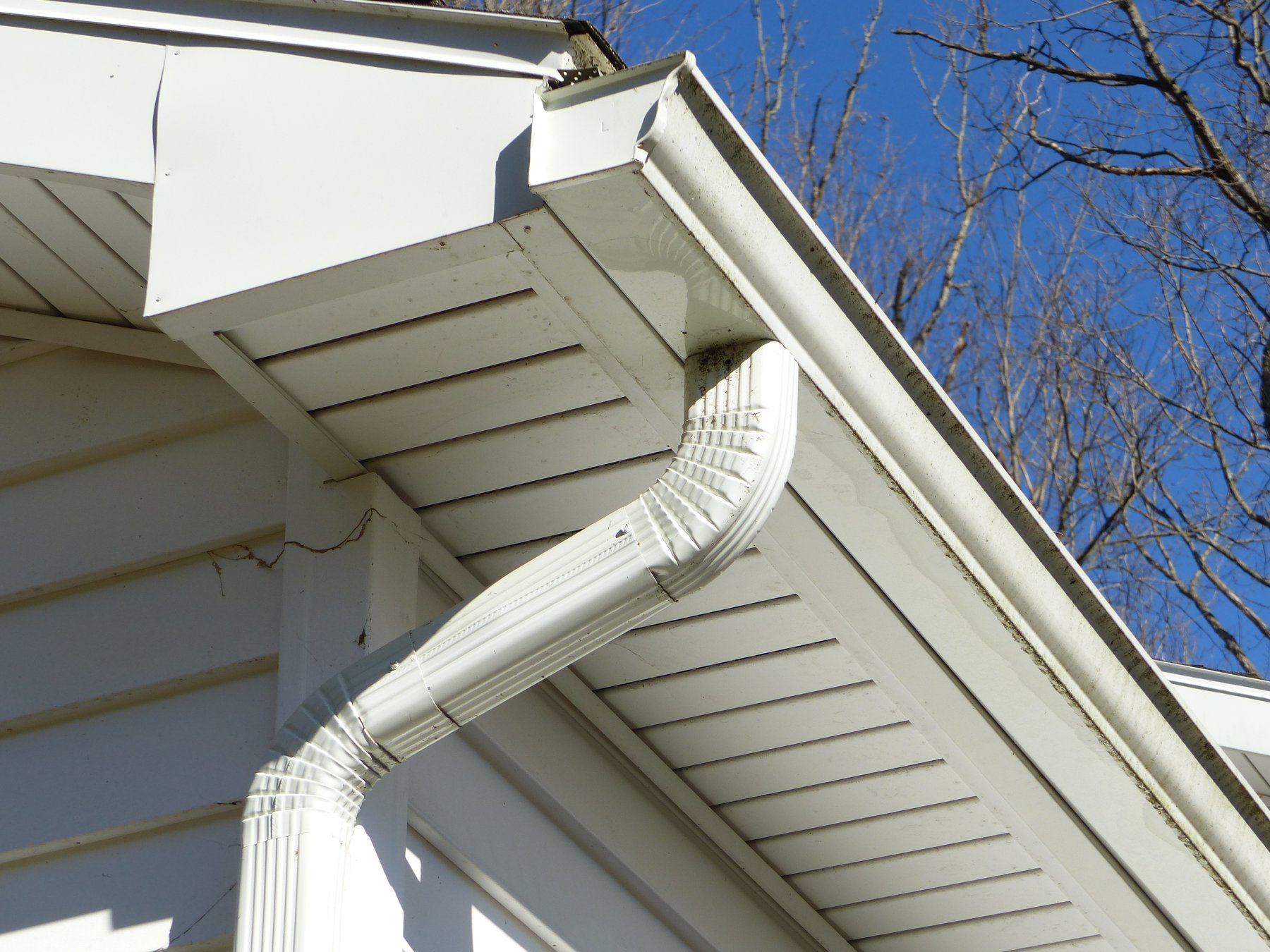 Gutter corner and soffit detail beneath a gabled roof